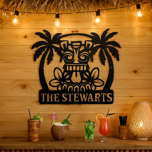 Decorative metal wall art with 'The Stewarts' on a wooden wall, surrounded by tropical drinks and decor.