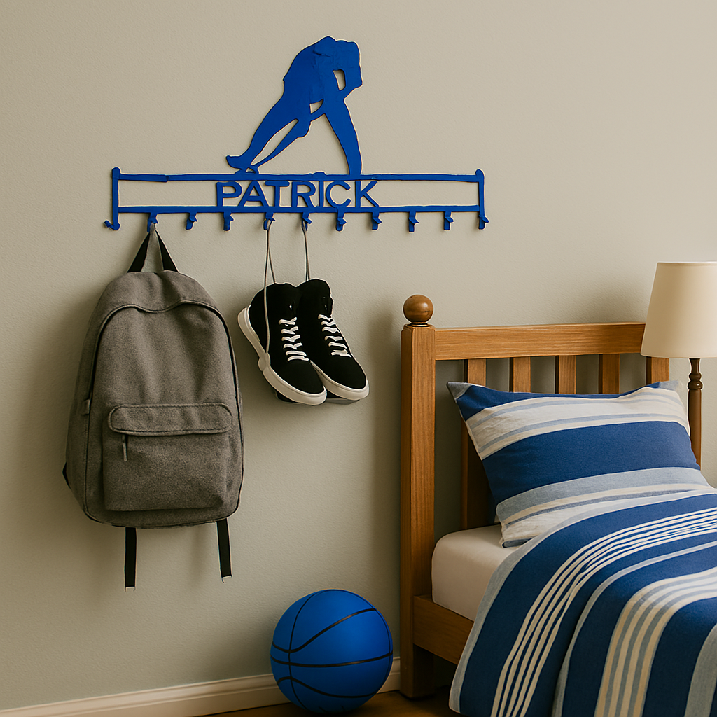 Wall-mounted sports-themed coat rack with 'Patrick' on it, next to a bed with blue and white bedding.