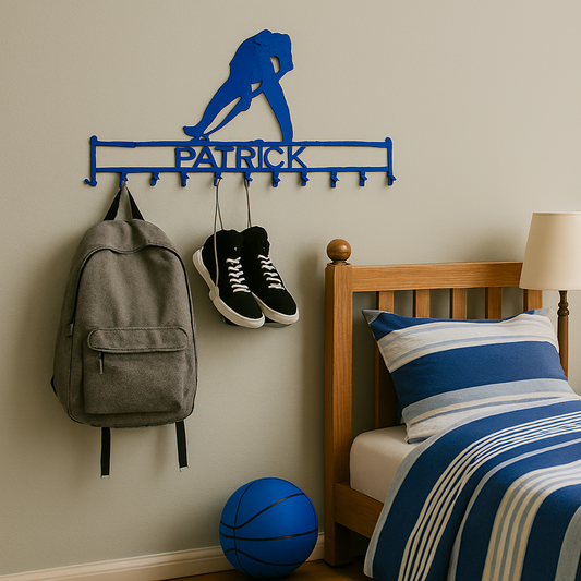 Wall-mounted sports-themed coat rack with 'Patrick' on it, next to a bed with blue and white bedding.