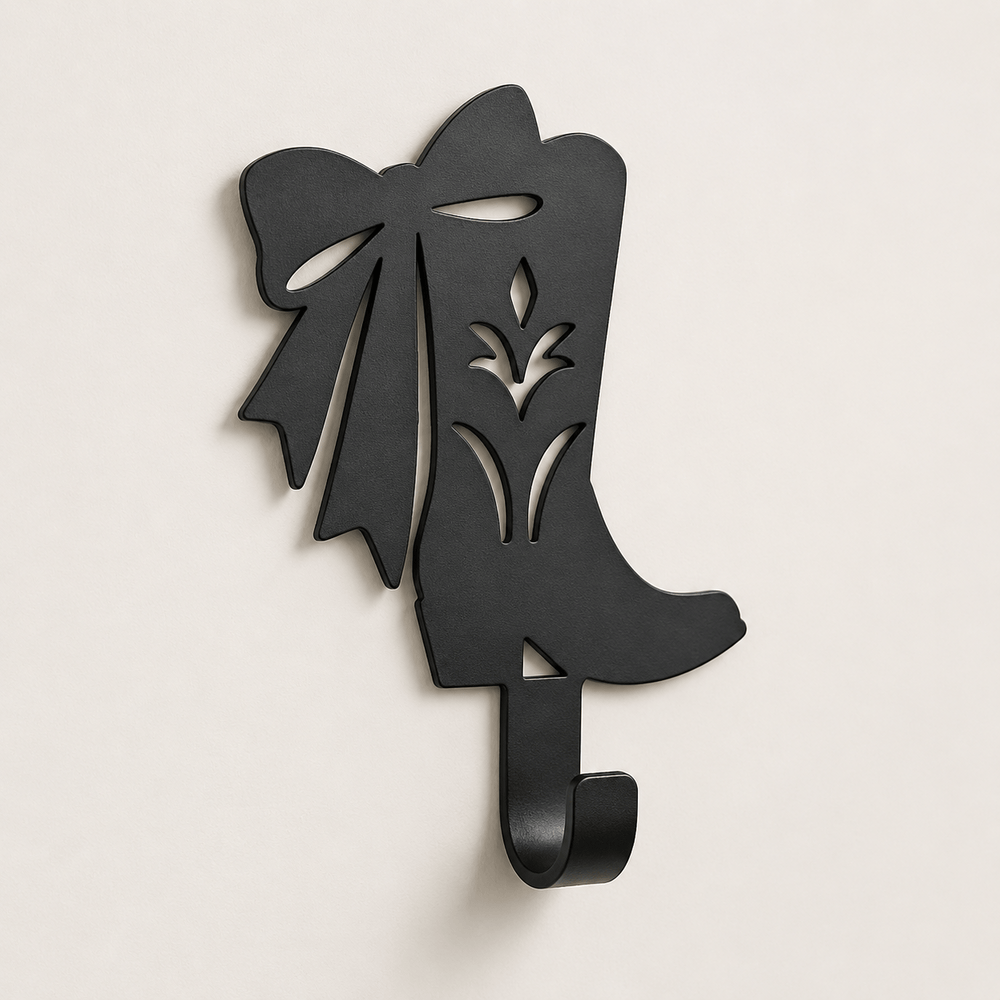 Close-up of Matte Black D73 cowgirl boot and bow metal sign with rolled coat hook