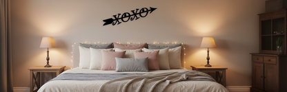 XOXO arrow sign on bedroom wall